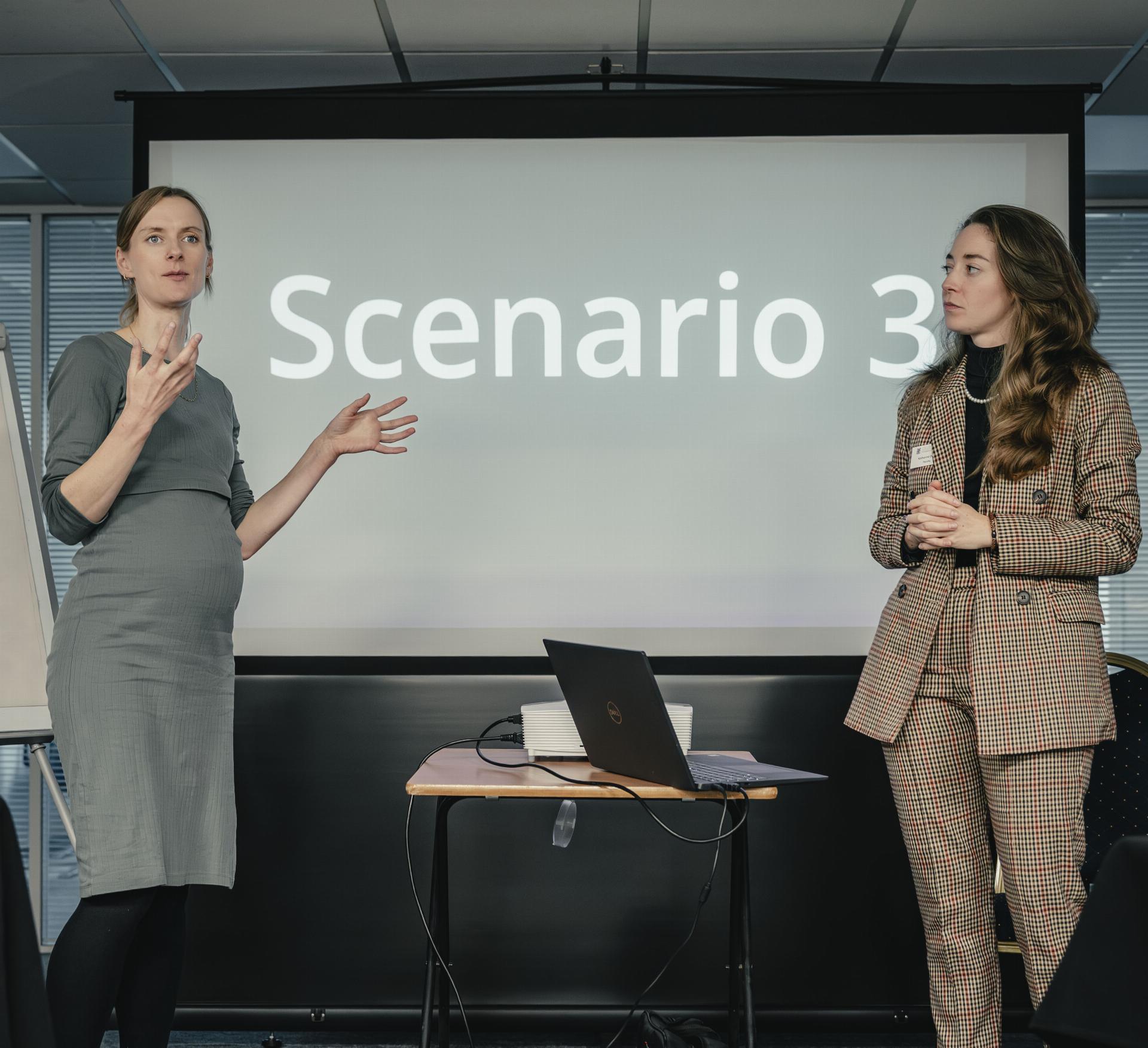 Two women presenting in front of a screen